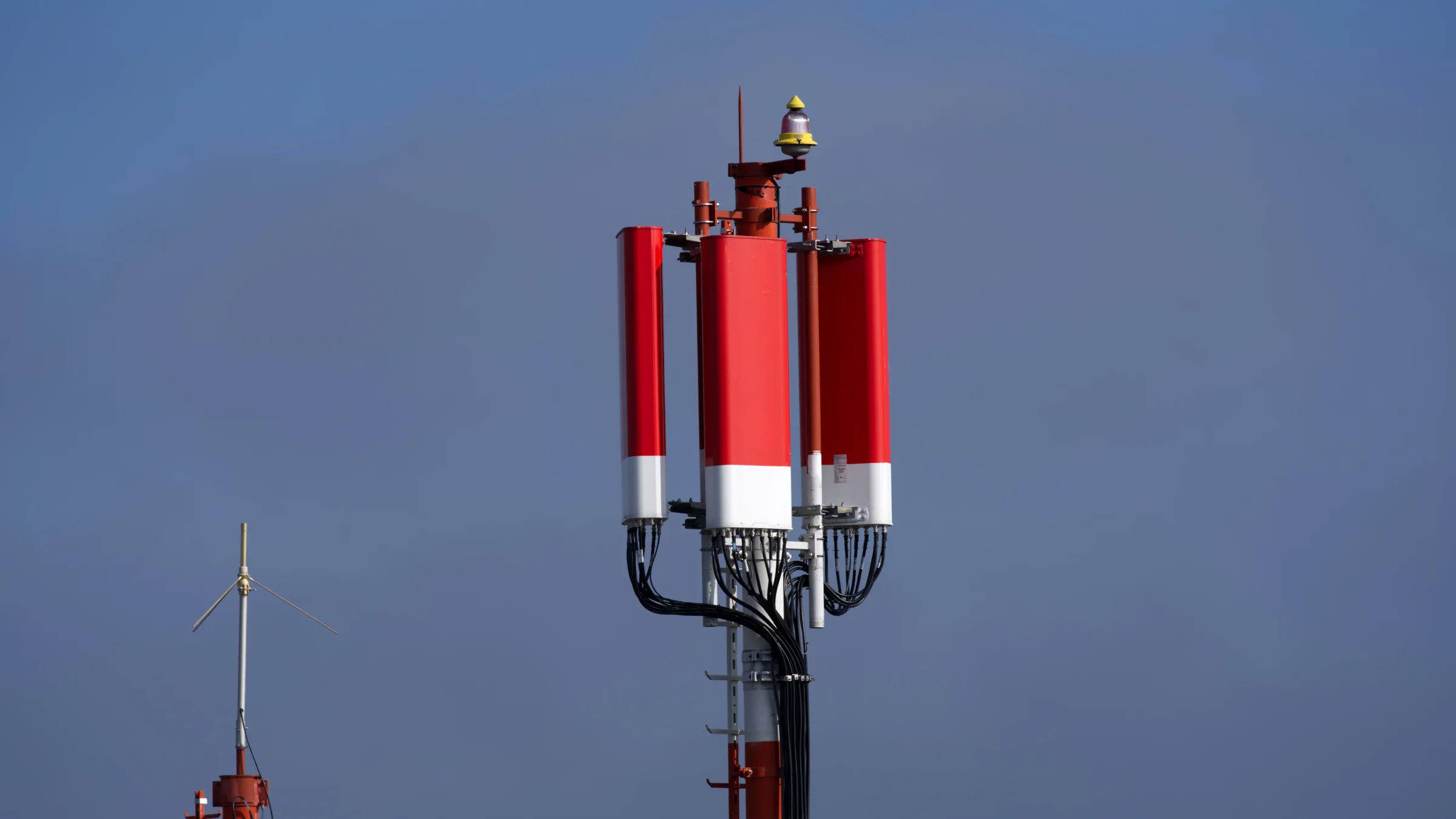 Pylône avec antennes panneau pour la couverture cellulaire, surmonté d'un feu d'obstacle